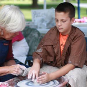 boy throwing on pottery wheel